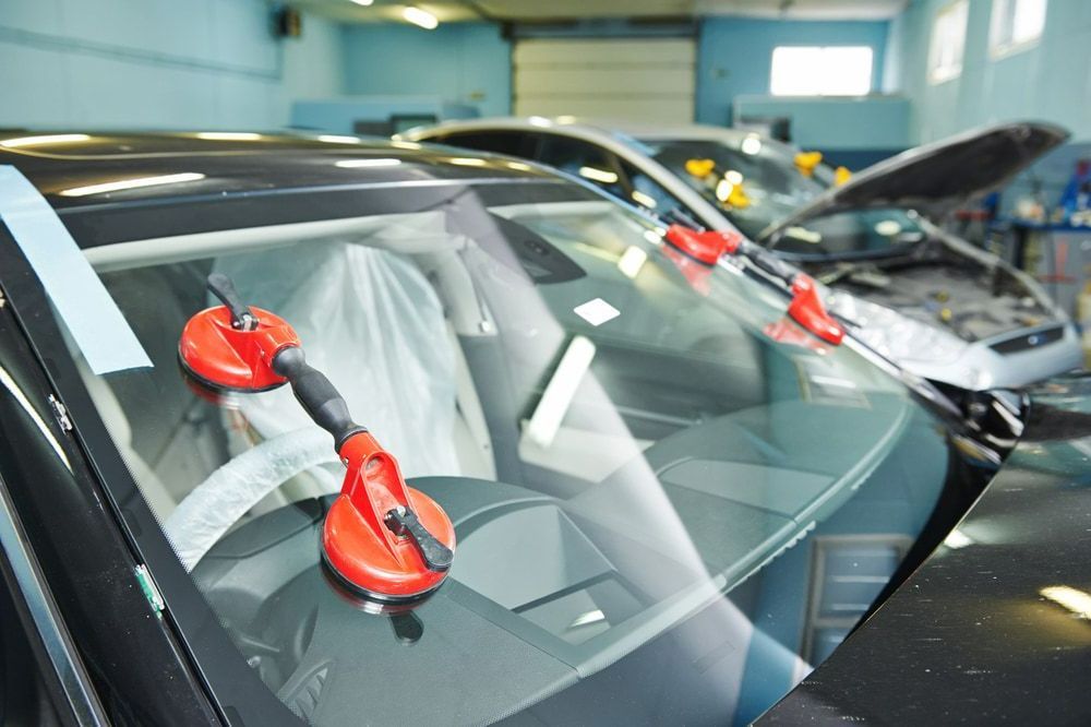 A Car Windshield Is Being Replaced In A Garage — Canberra Windscreens In Weston Creek, ACT