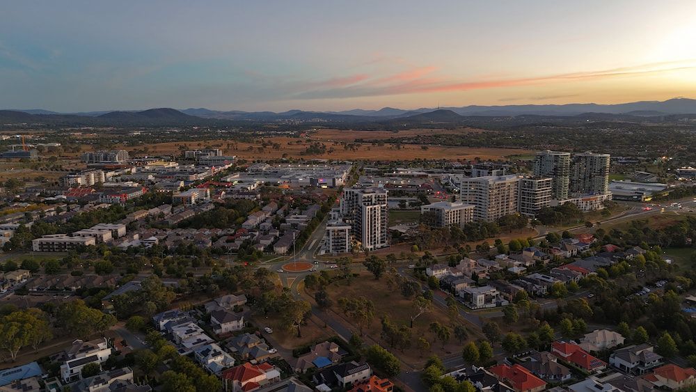 An Aerial View Of A City At Sunset With Mountains In The Background — Canberra Windscreens In Gungahlin, ACT