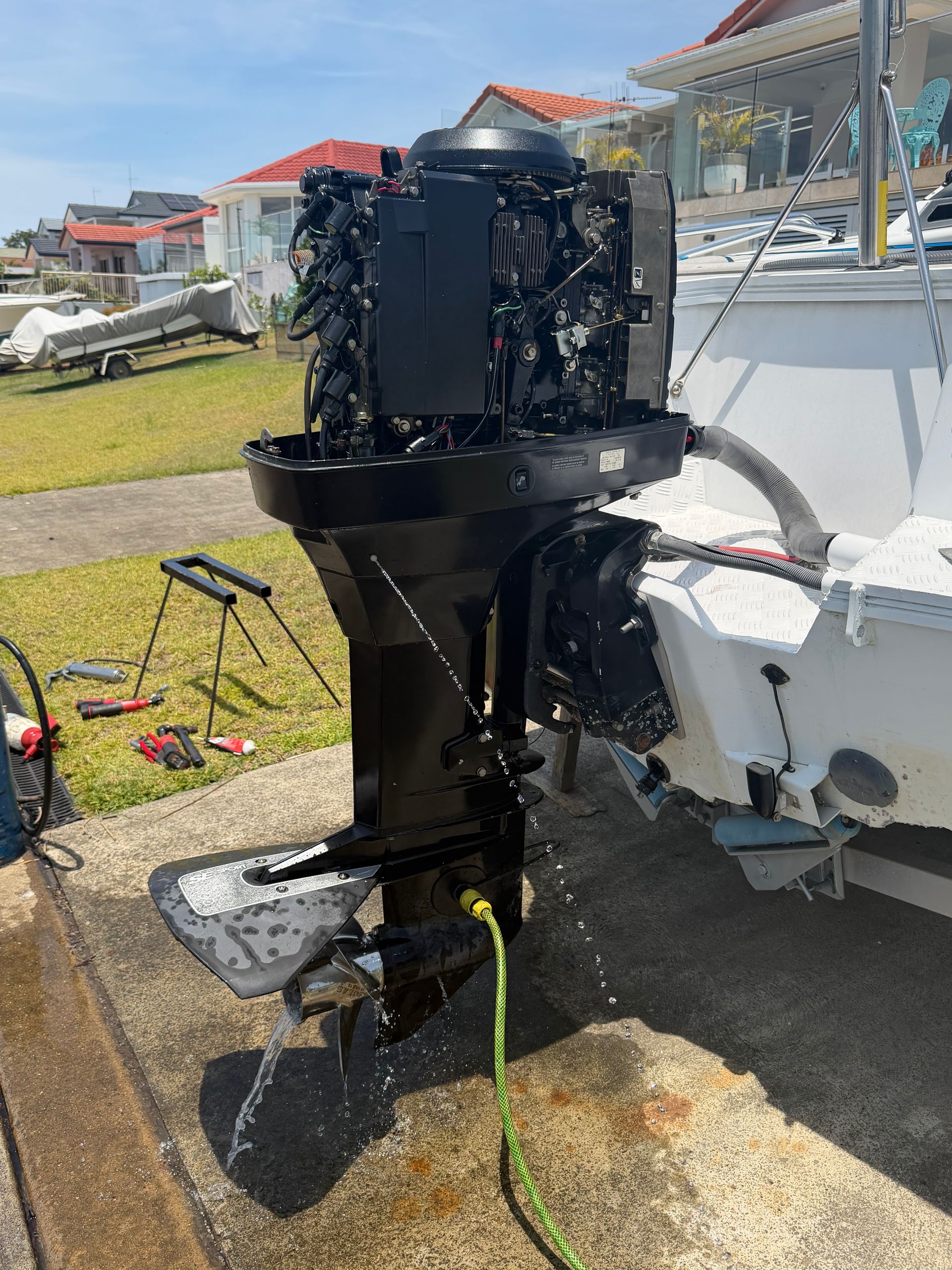 A Boat Motor With Its Cover Removed, Attached to the Stern of a Boat — Hastings Mobile Marine Services In Wauchope, NSW