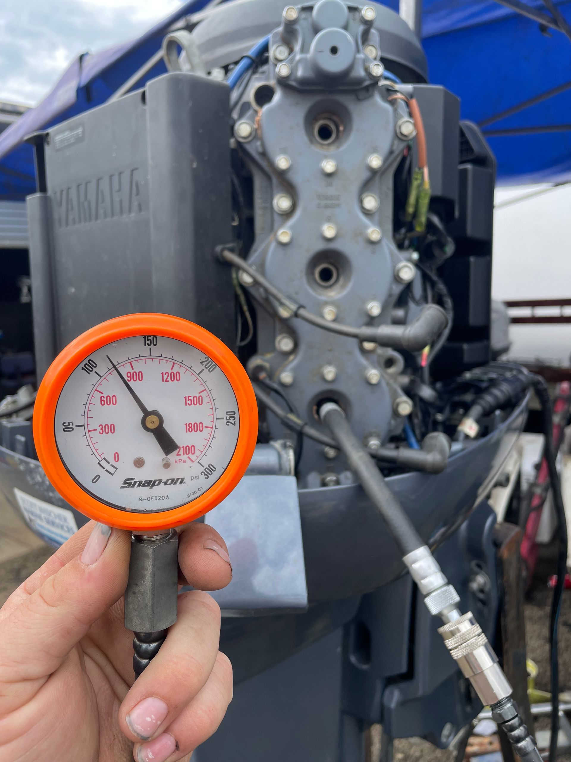 A Hand Holds a Compression Gauge Showing Approx 110 Psi — Hastings Mobile Marine Services In Laurieton, NSW