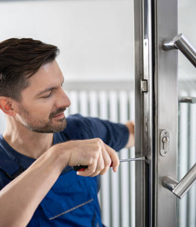 A man is fixing a door with a screwdriver.