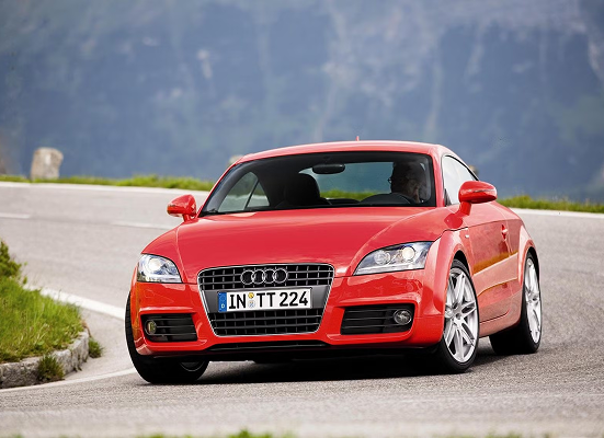 A red audi tt 224 is driving down a road