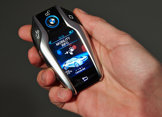 A person is holding a bmw key fob in their hand
