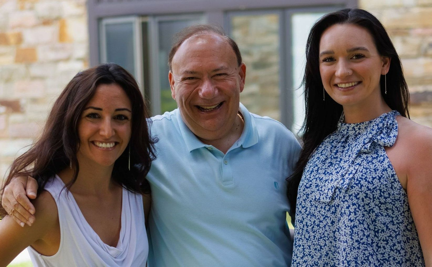 A man and two women are posing for a picture together.