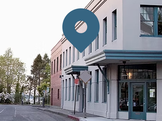 Building corner with blue door and teal location pin over it. Street view.