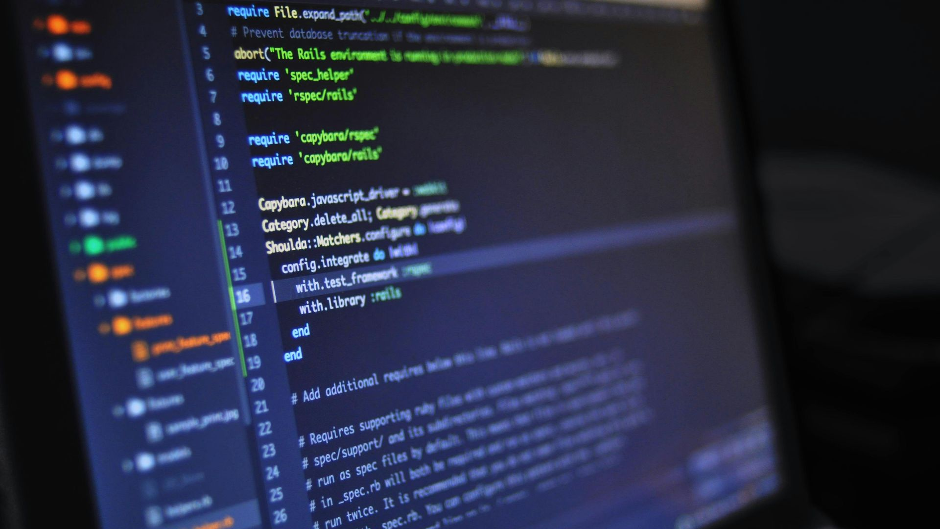 A laptop screen displaying lines of computer code in a text editor with a file directory visible on the left.