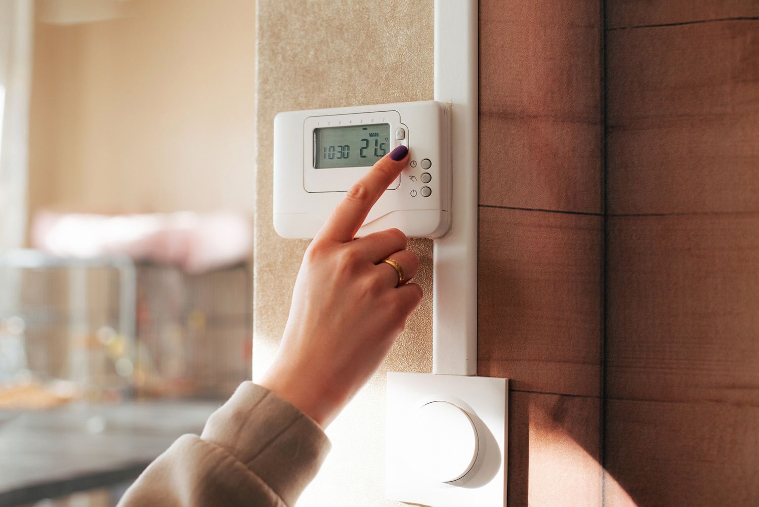 Person adjusting the thermostat