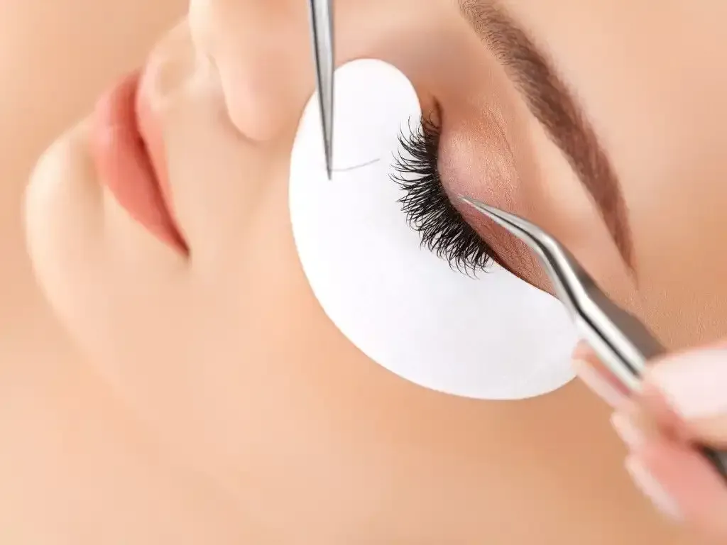 Close-up of light blue eyes with long, dark eyelashes after a lash lift, looking upwards.