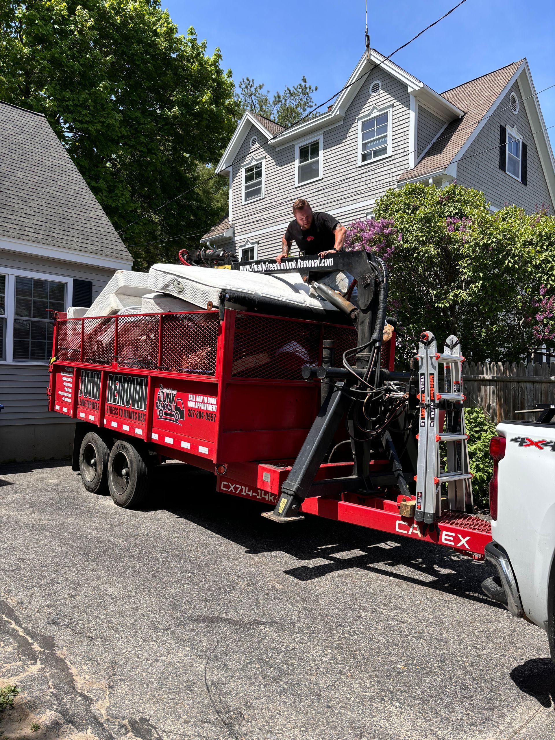 Finally Freedom Junk Removal loading junk mattresses into their trailer