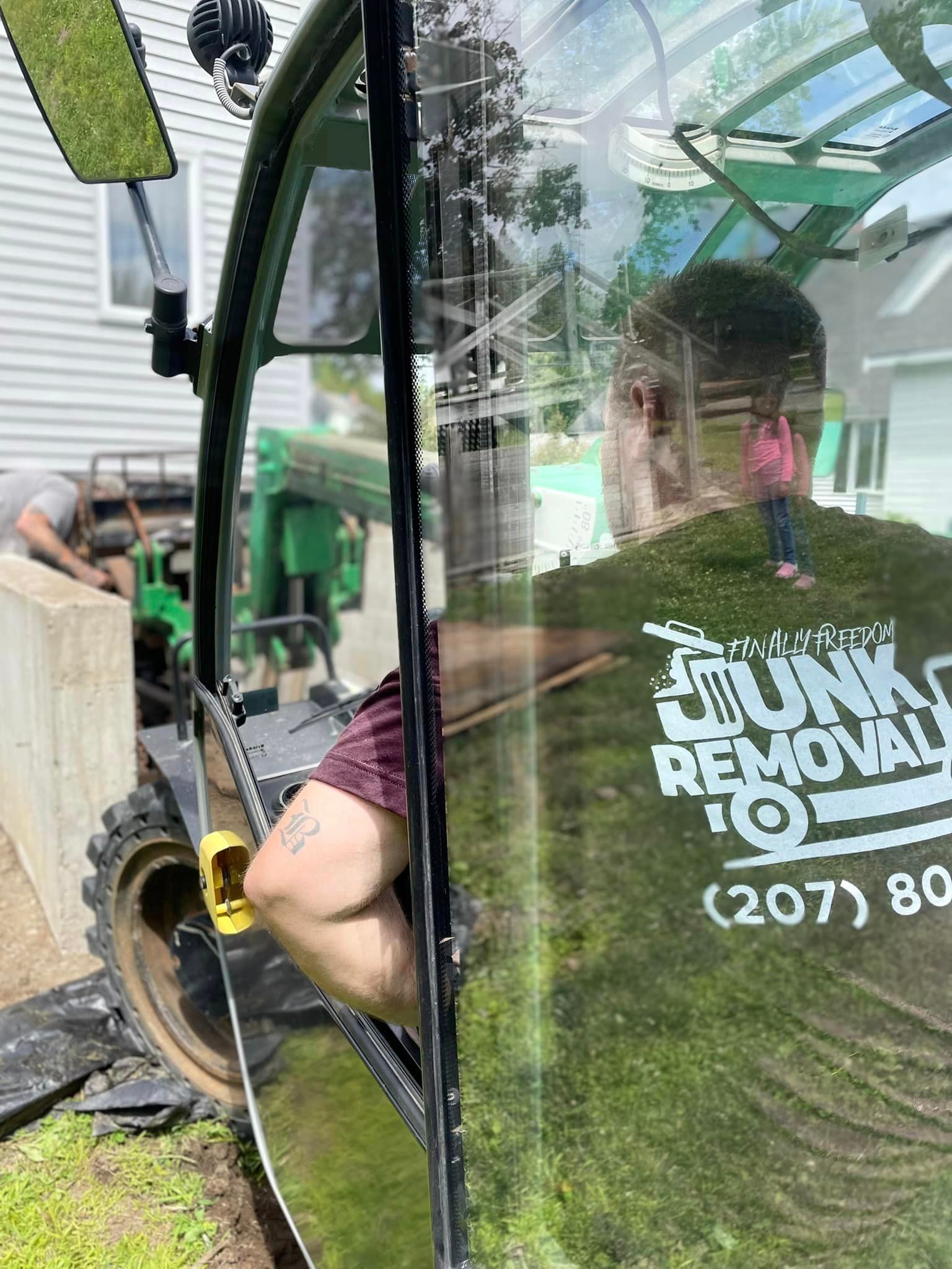 A Finally Freedom Junk Removal employee operating a tractor