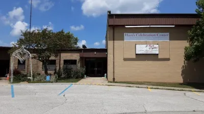 Tan brick building with a sign: 