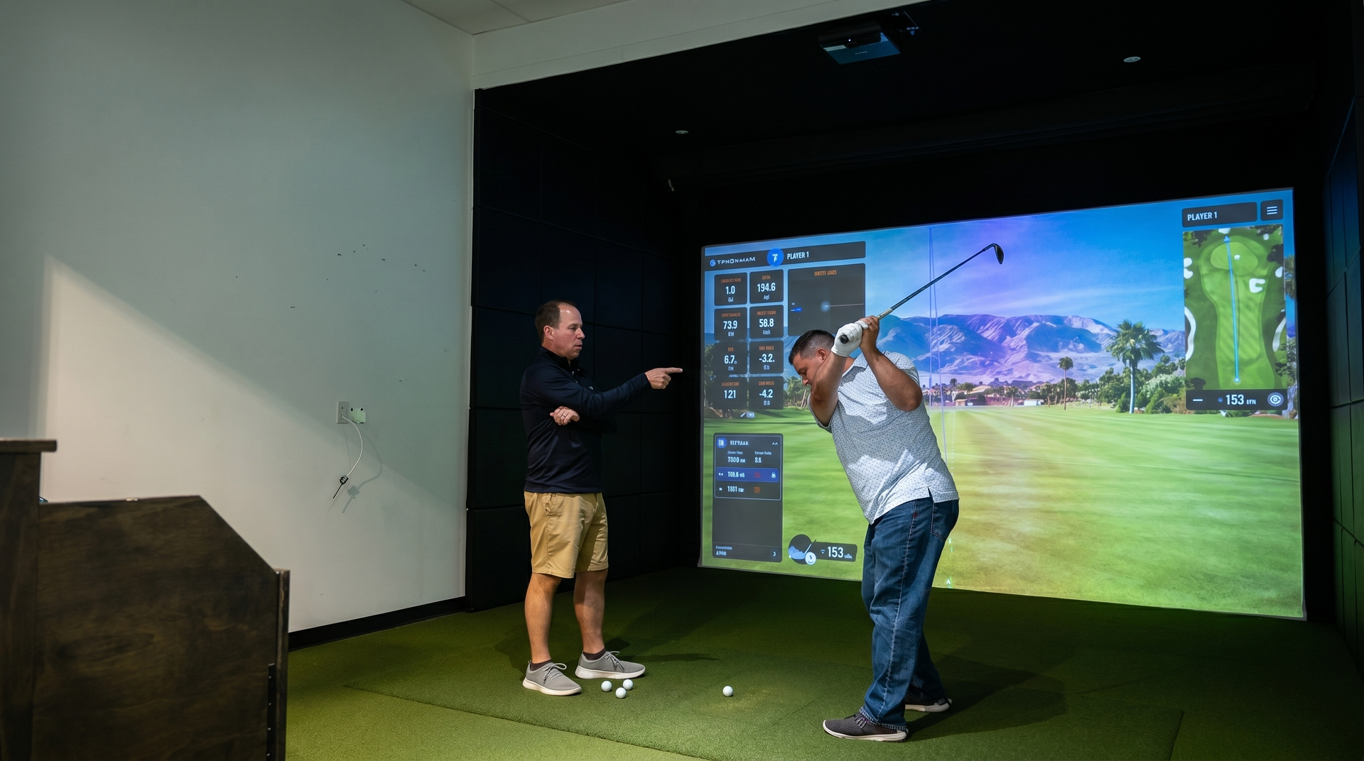 Two golfers playing an indoor virtual round on TrackMan golf simulator