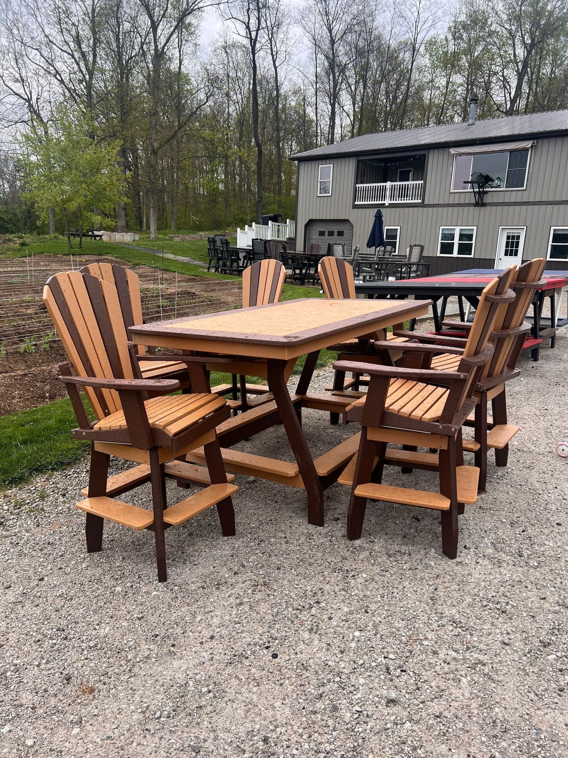 A table and chairs are sitting on gravel in front of a house.