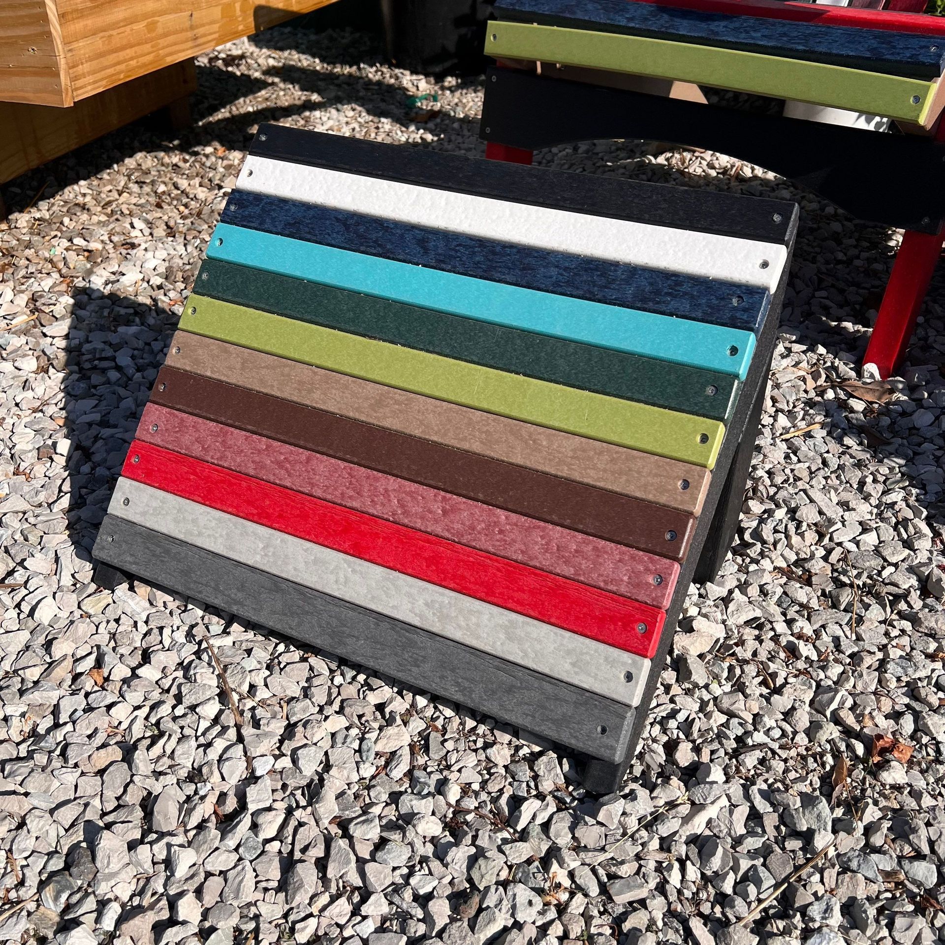 A colorful ottoman is sitting on a pile of gravel.