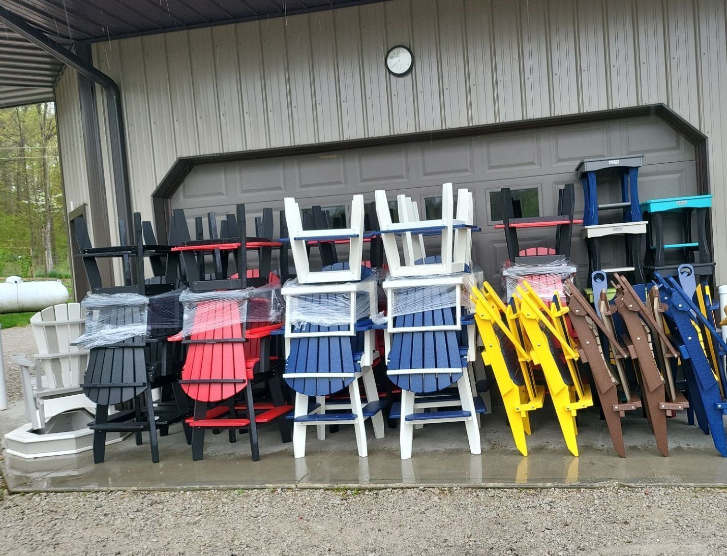 A bunch of chairs are stacked on top of each other in front of a building.