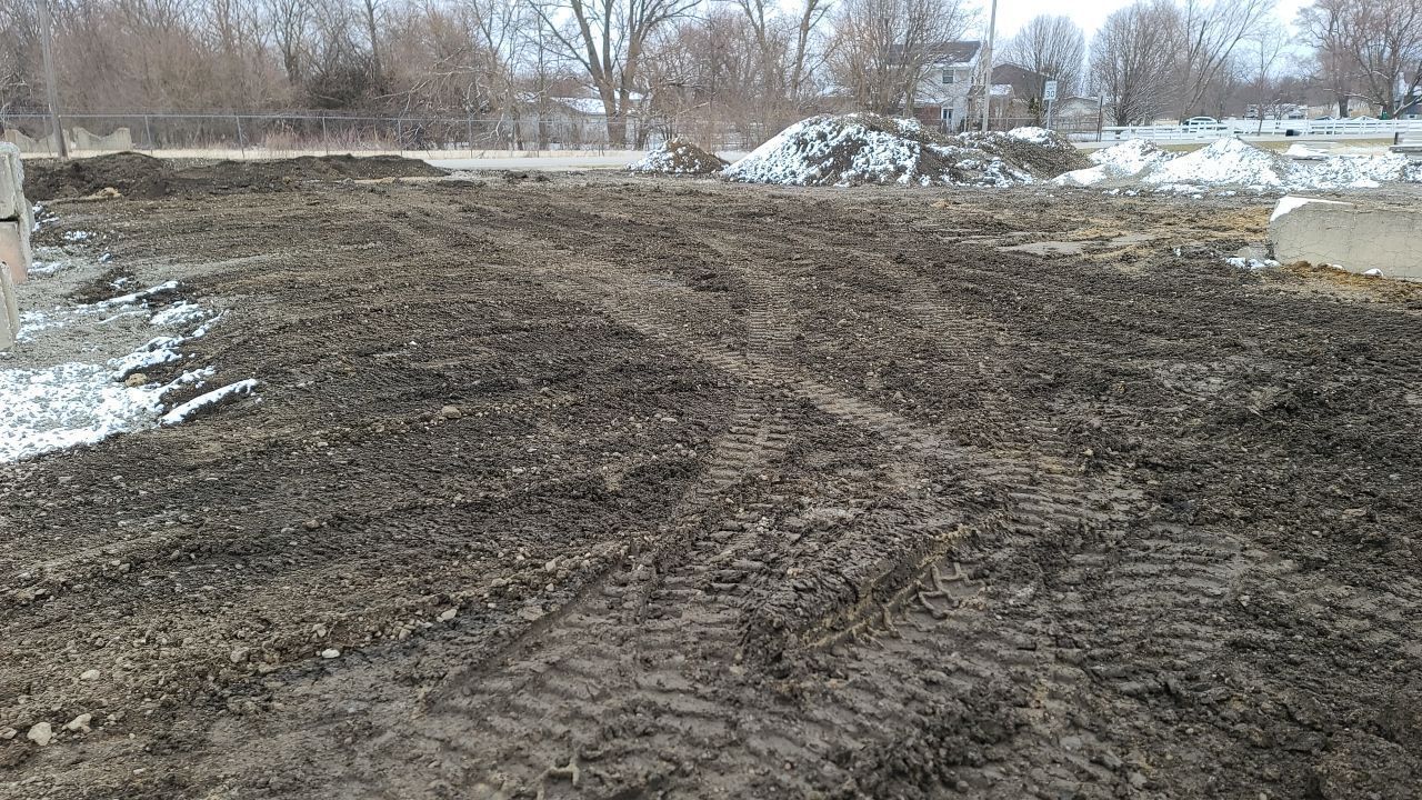 A muddy field with a lot of tire tracks in it.