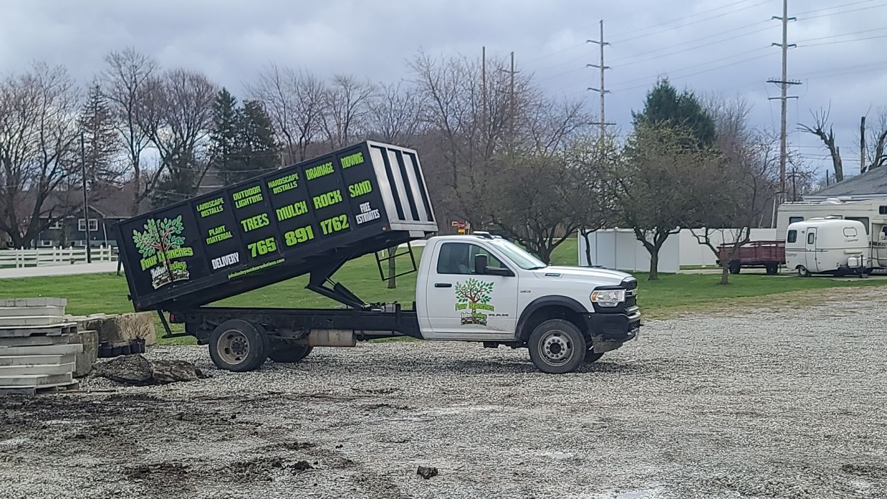 A dump truck is parked in a gravel lot.