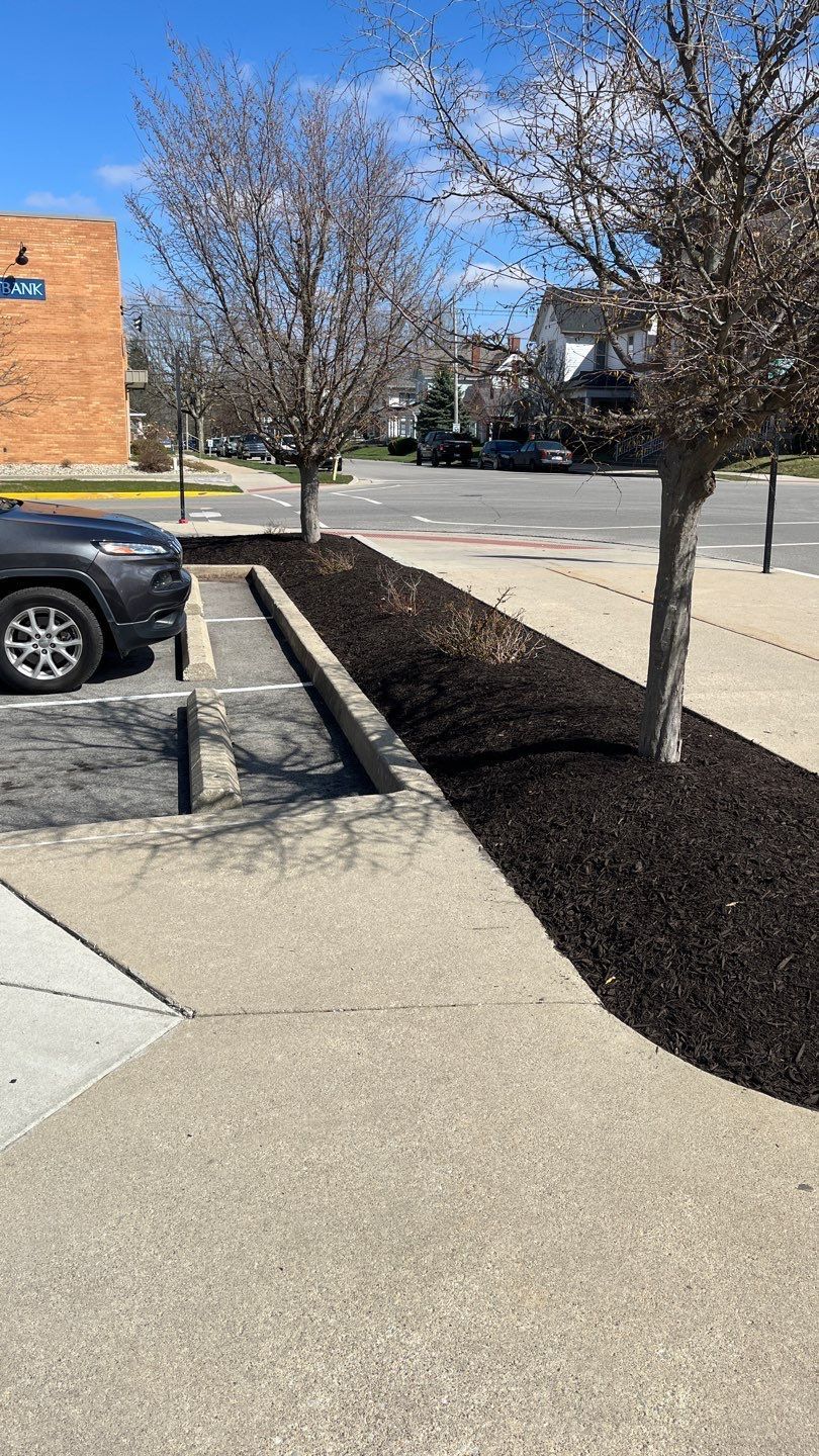 A car is parked in a parking lot next to a sidewalk.