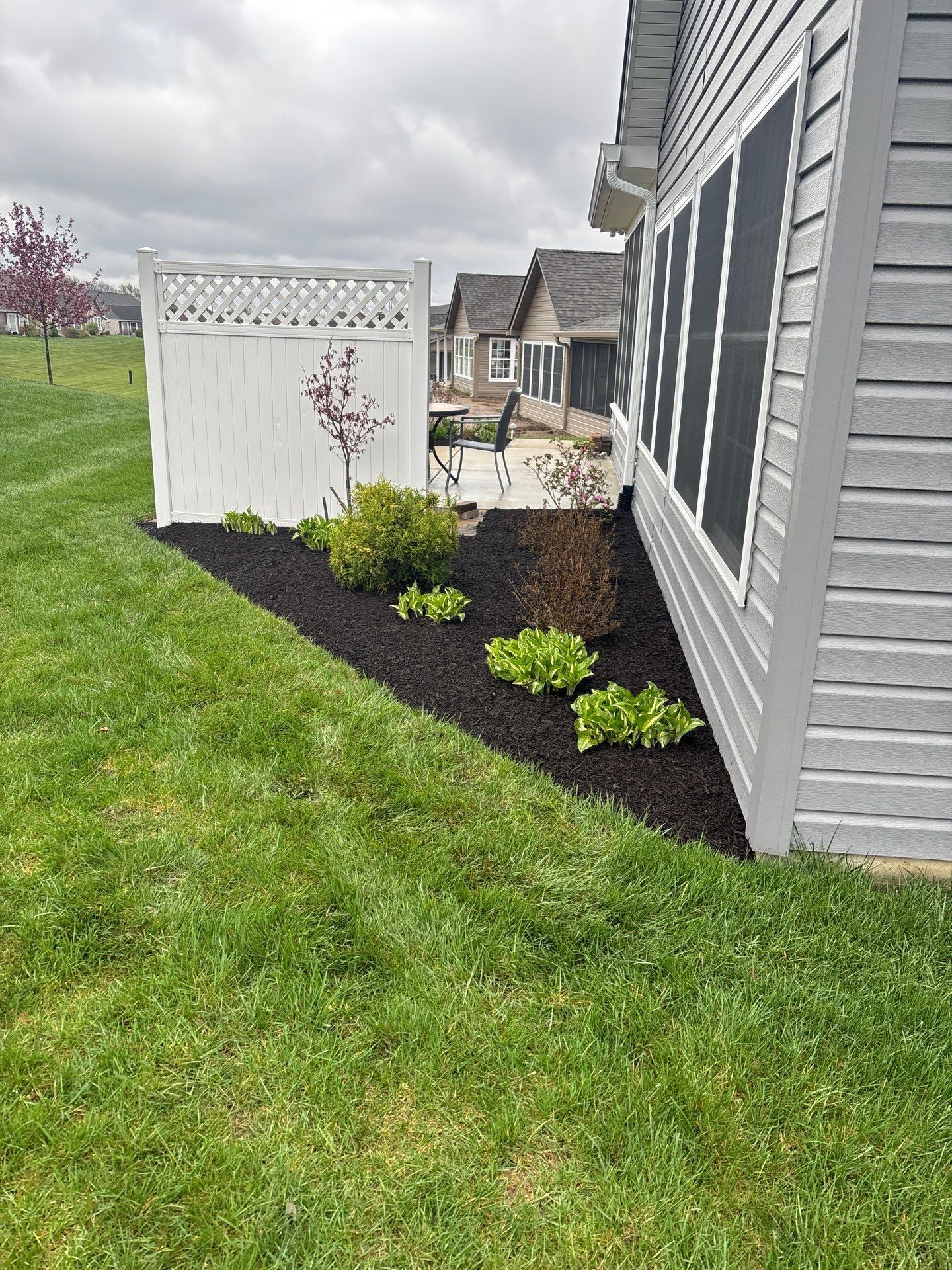 There is a white fence in the backyard of a house.