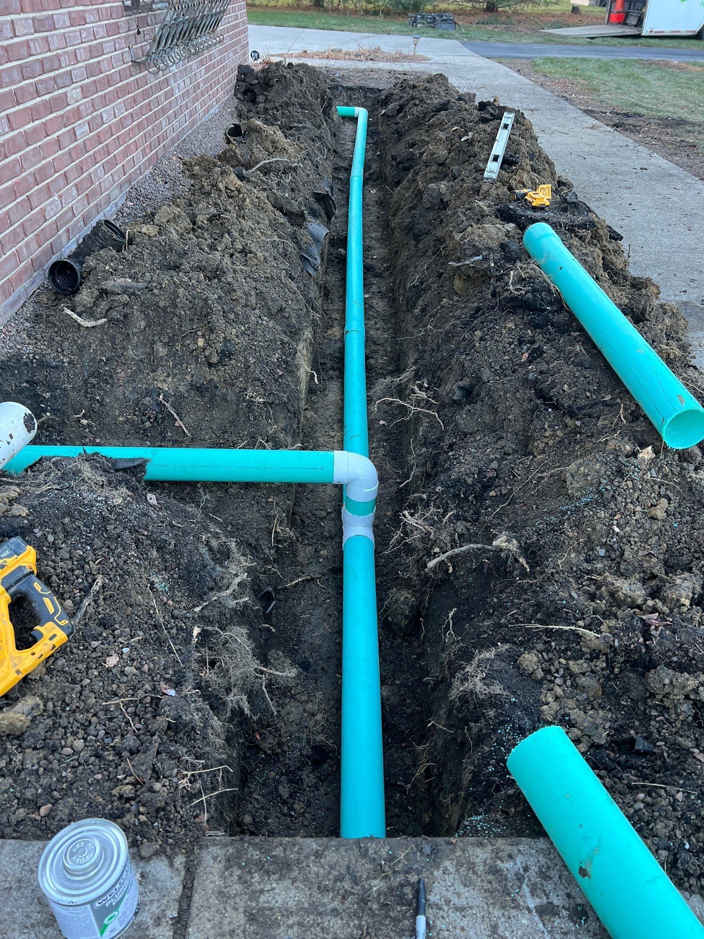 A drain pipe is being installed in a hole in the ground.