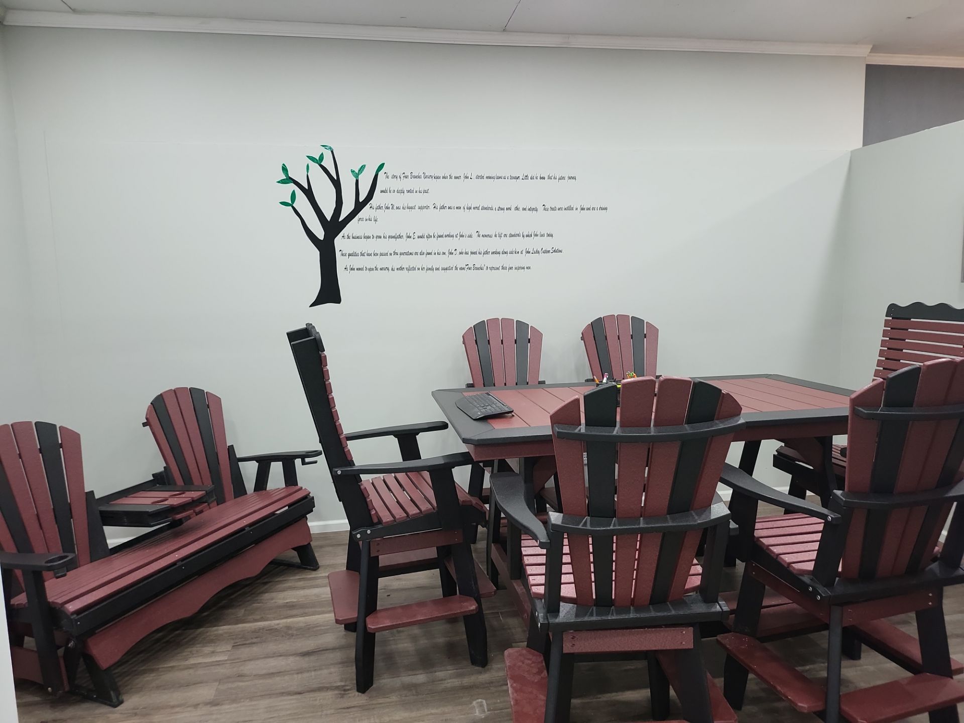 A room with a table and chairs and a tree on the wall.