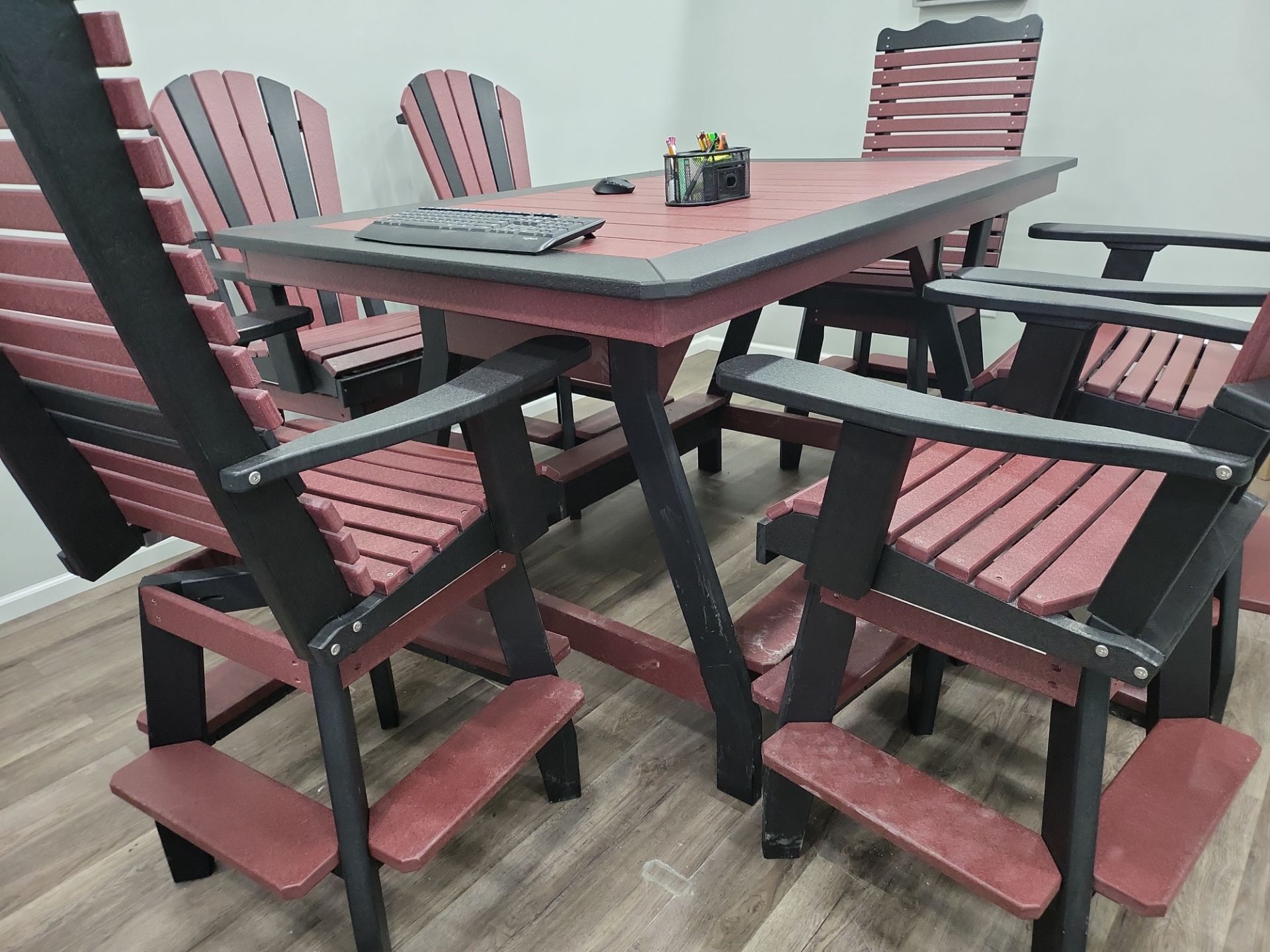 A table and chairs are sitting on a wooden floor in a room.