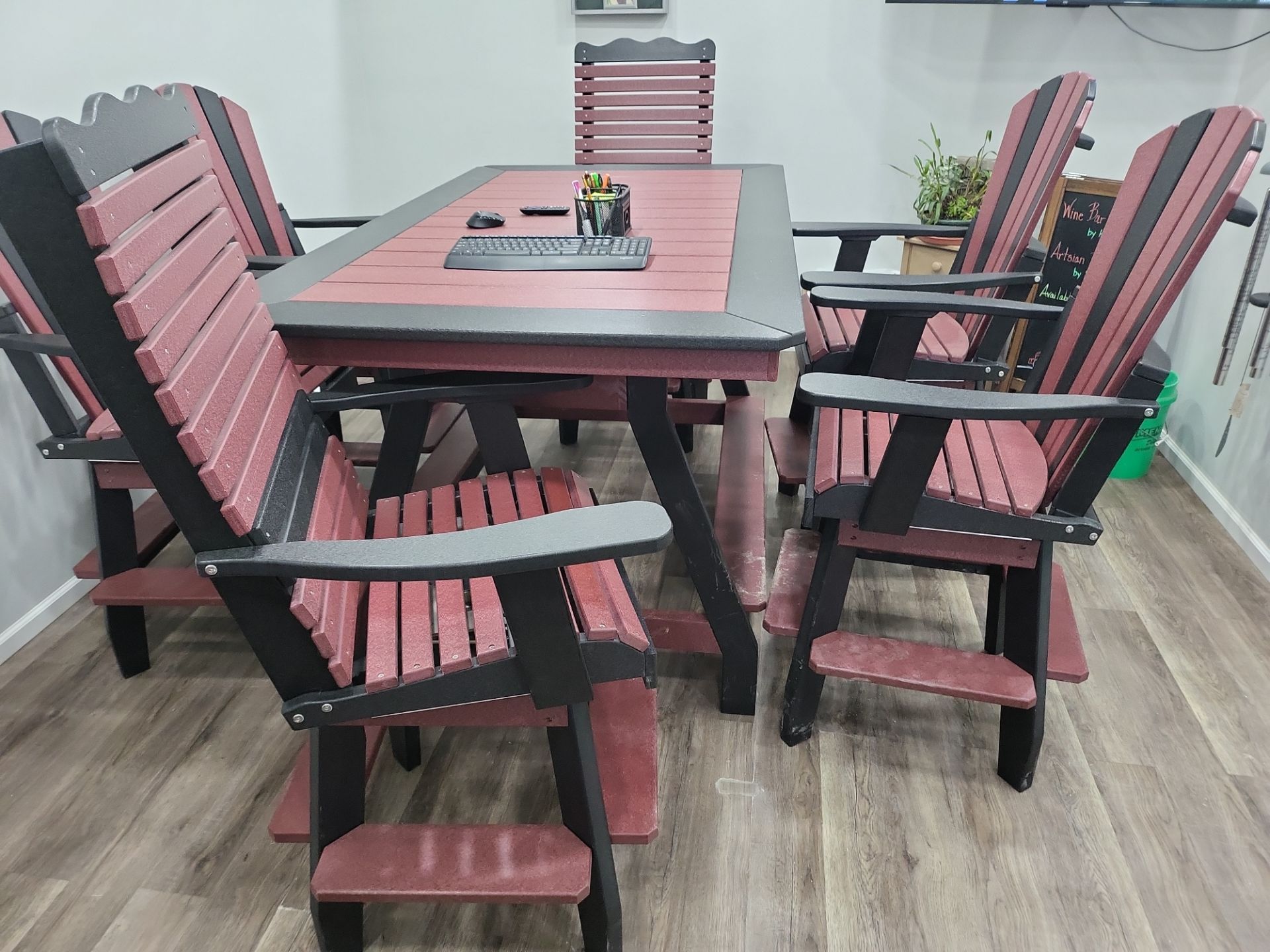 A table and chairs are sitting on a wooden floor in a room.
