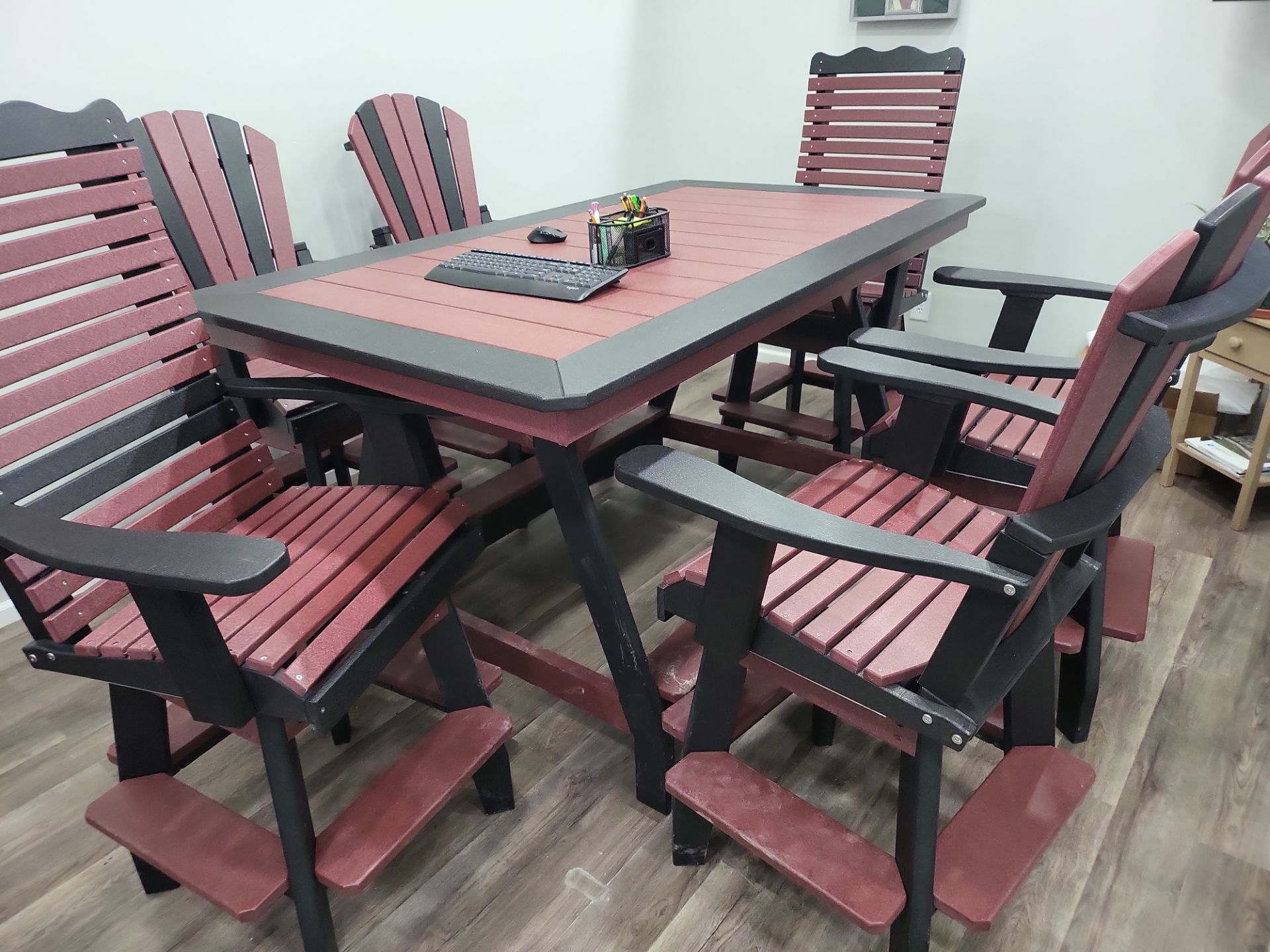 A table and chairs are sitting on a wooden floor in a room.
