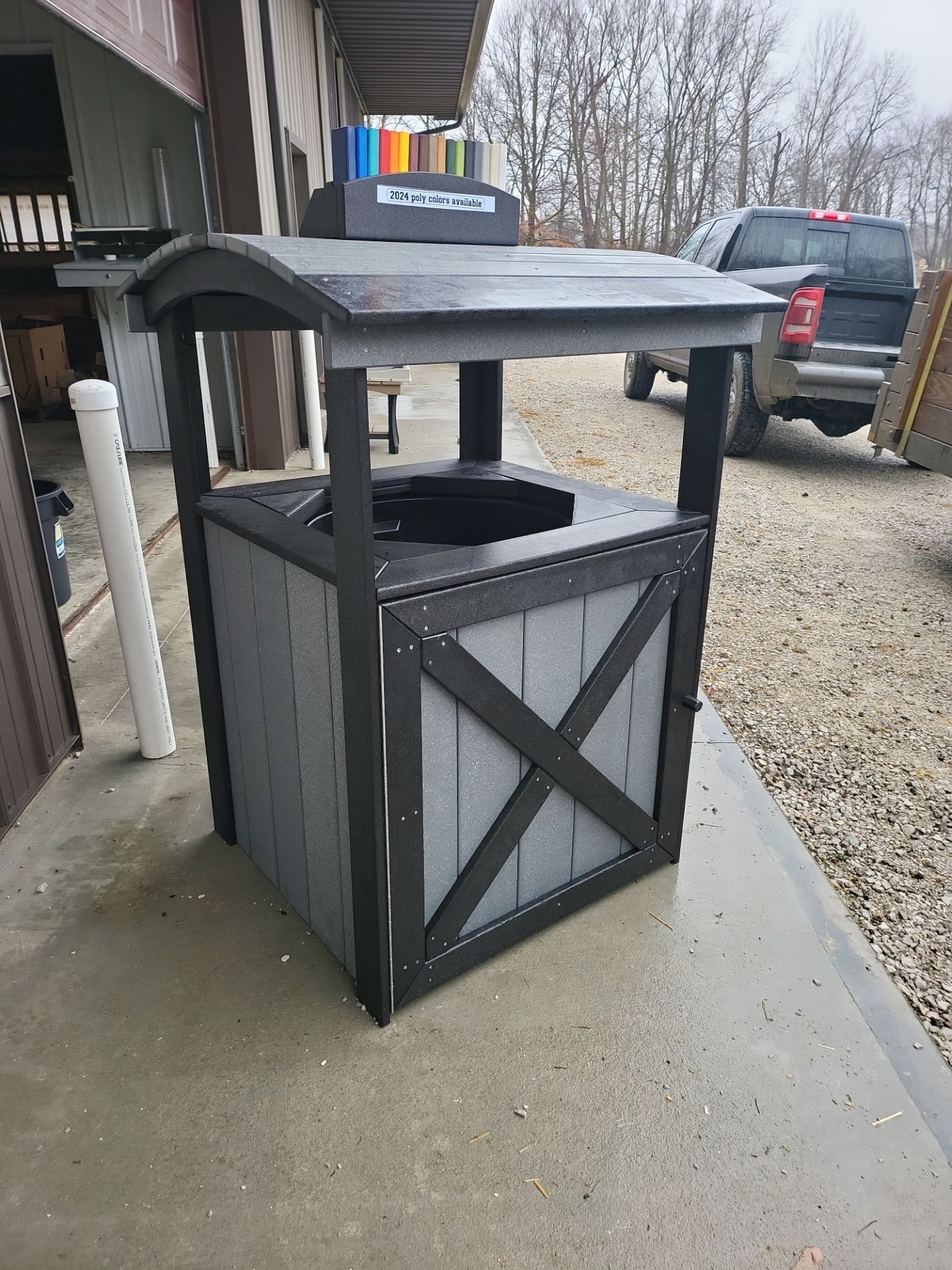 A trash can is sitting on a sidewalk in front of a building.