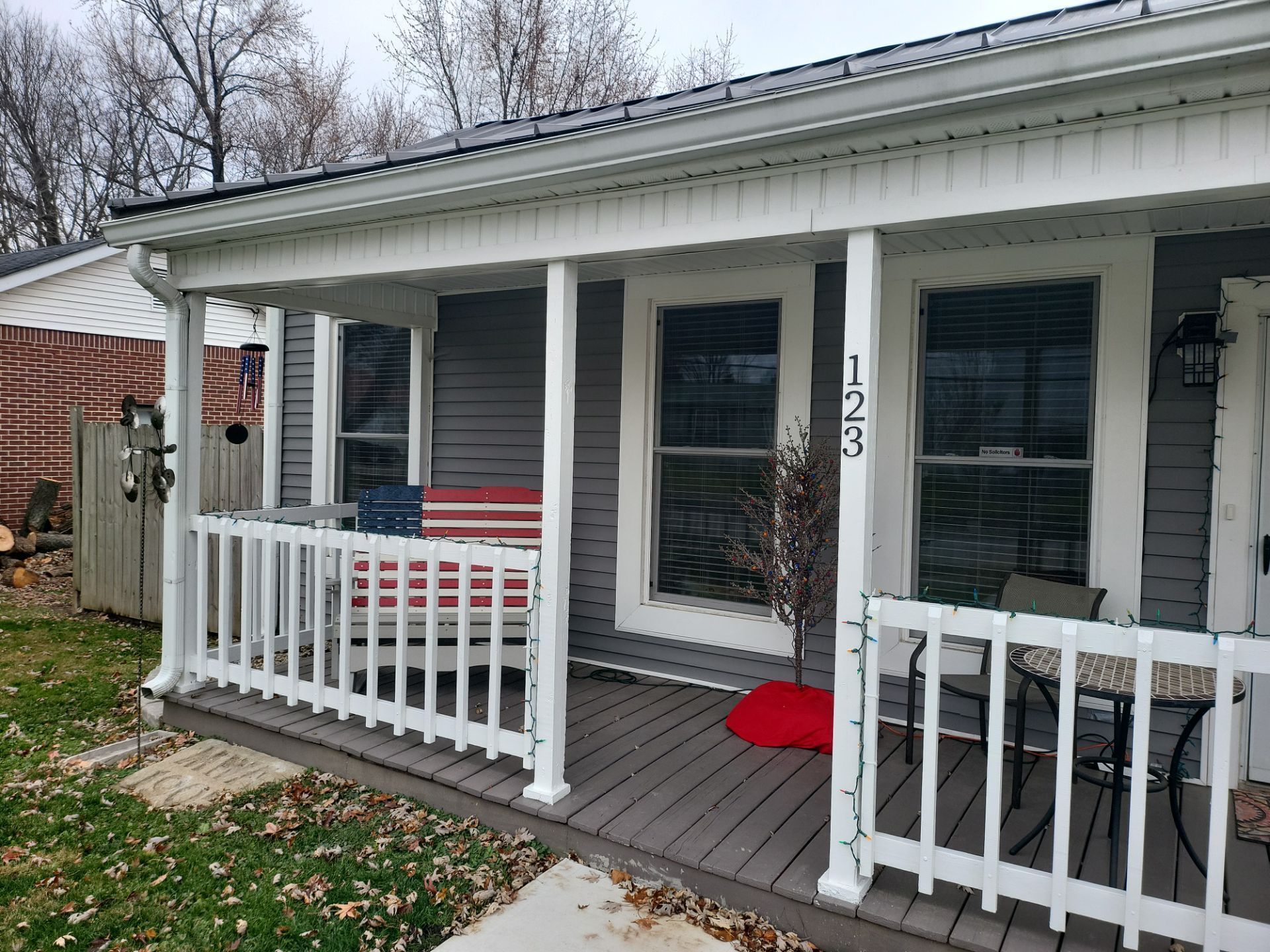 A porch with a red , white and blue american flag on it.