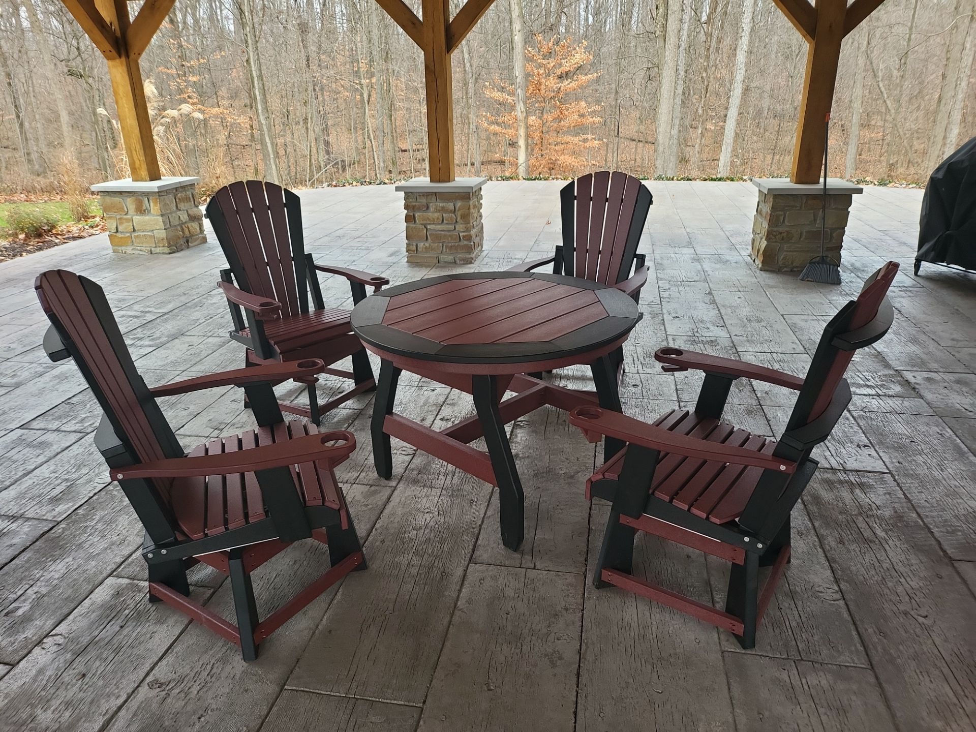 A table and chairs on a patio with trees in the background