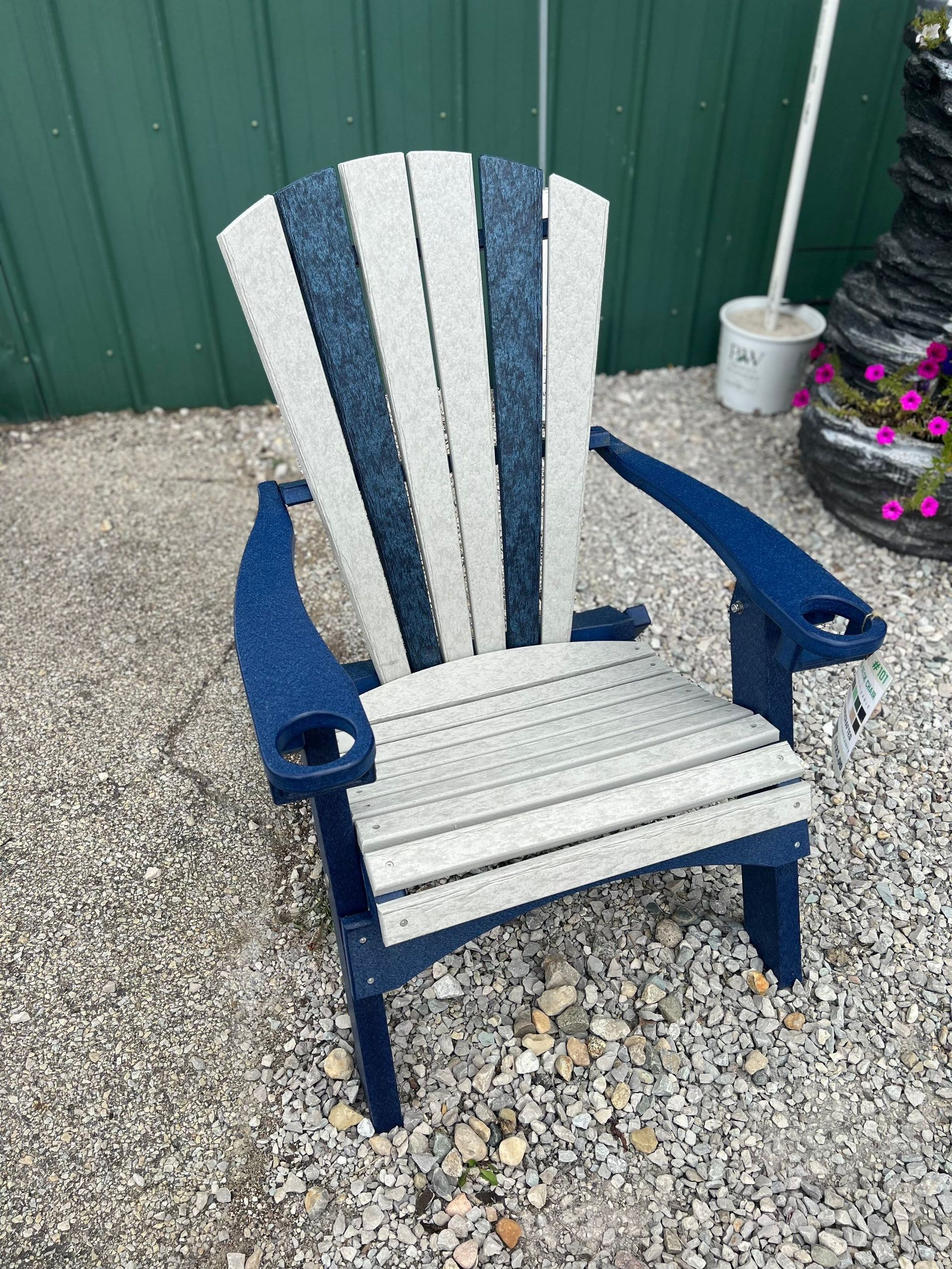 A blue and white chair is sitting on a pile of gravel.