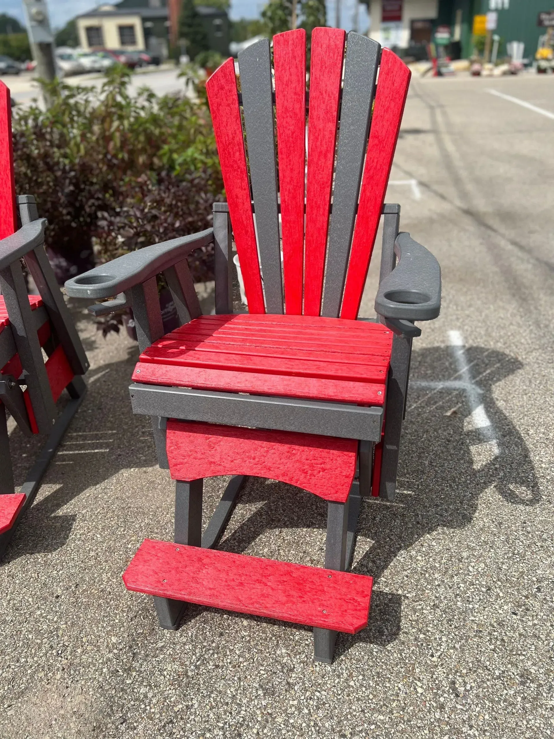 A red and gray chair is sitting on a gravel road.