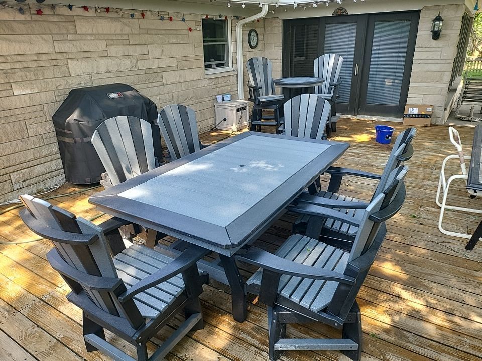 A wooden deck with a table and chairs on it.