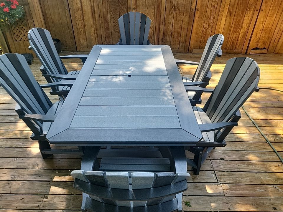 A table and chairs are sitting on a wooden deck.