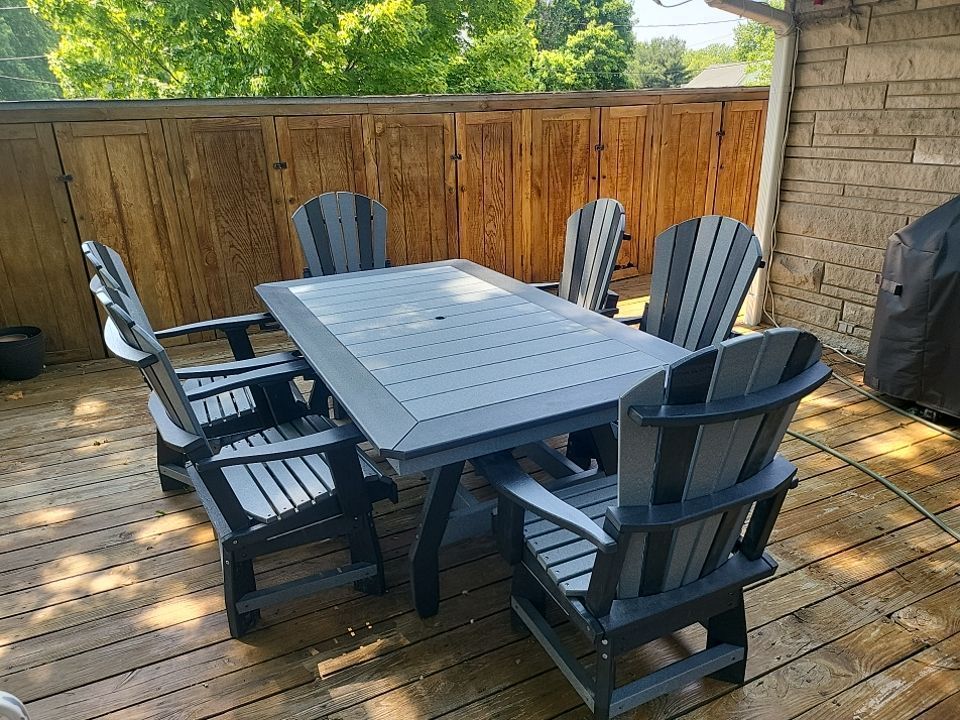 A wooden deck with a table and chairs on it.