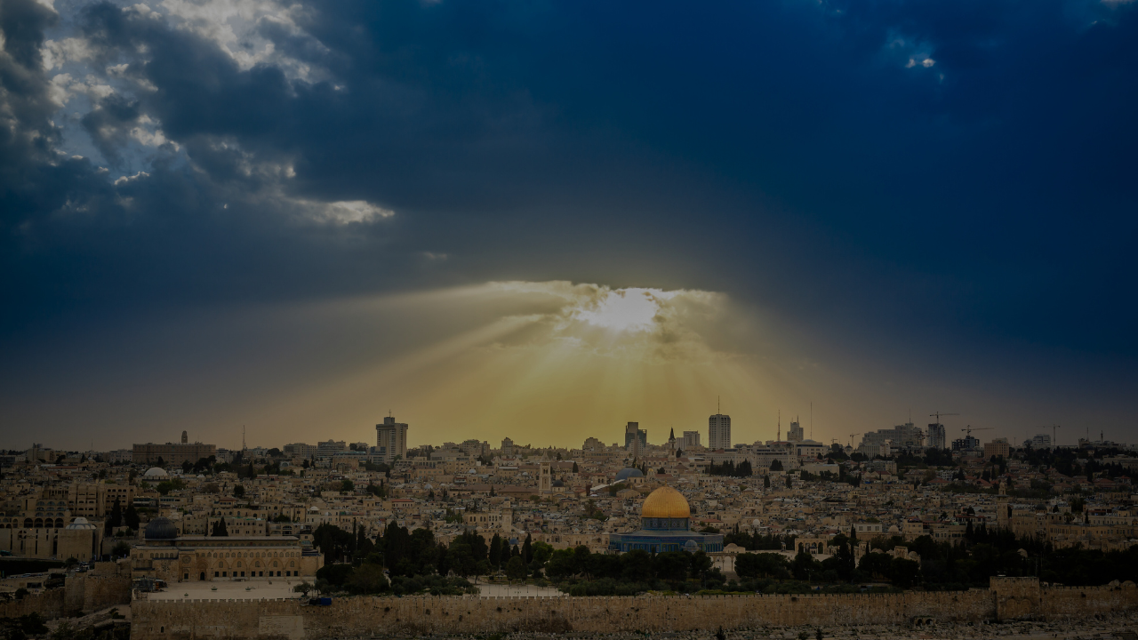 Panoramic view of Jerusalem with the Dome of the Rock illuminated by sunlight breaking through the clouds