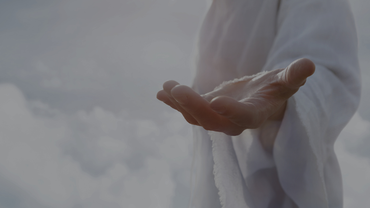 Close-up of an outstretched hand representing Jesus offering help and compassion in a white robe