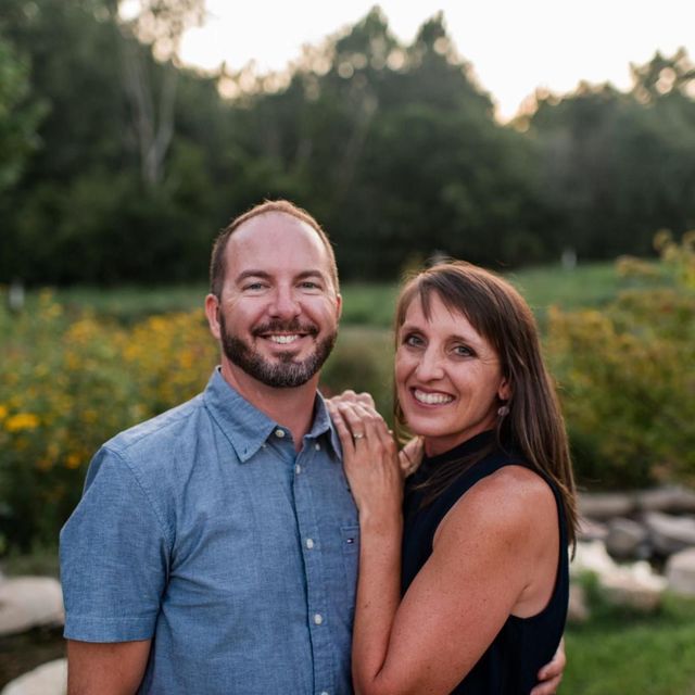 Pastor and his wife standing in a garden at golden hour