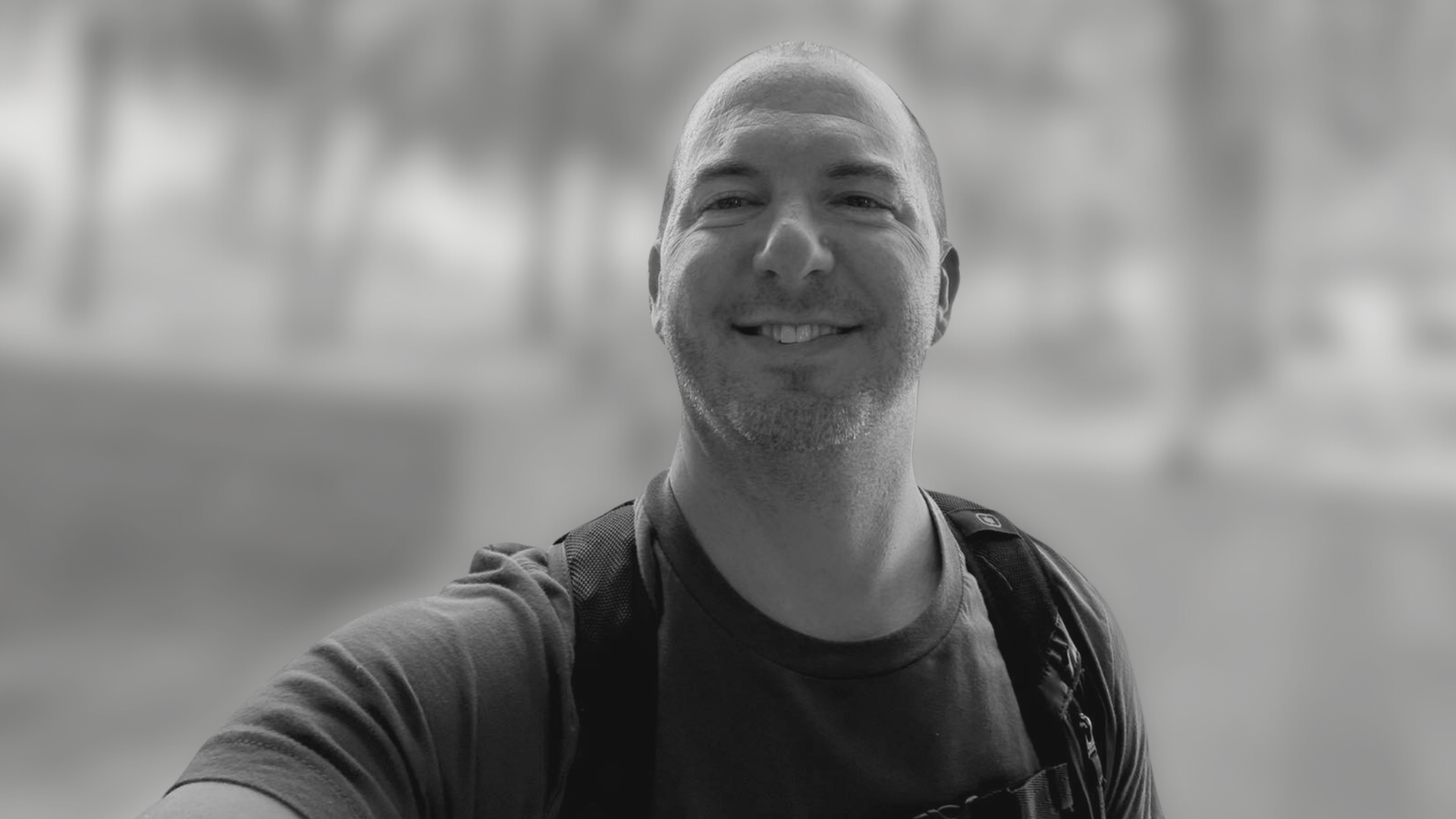 Black-and-white profile selfie of Pastor Joel Nafziger smiling at the camera