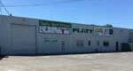 Gray industrial building with green sign for