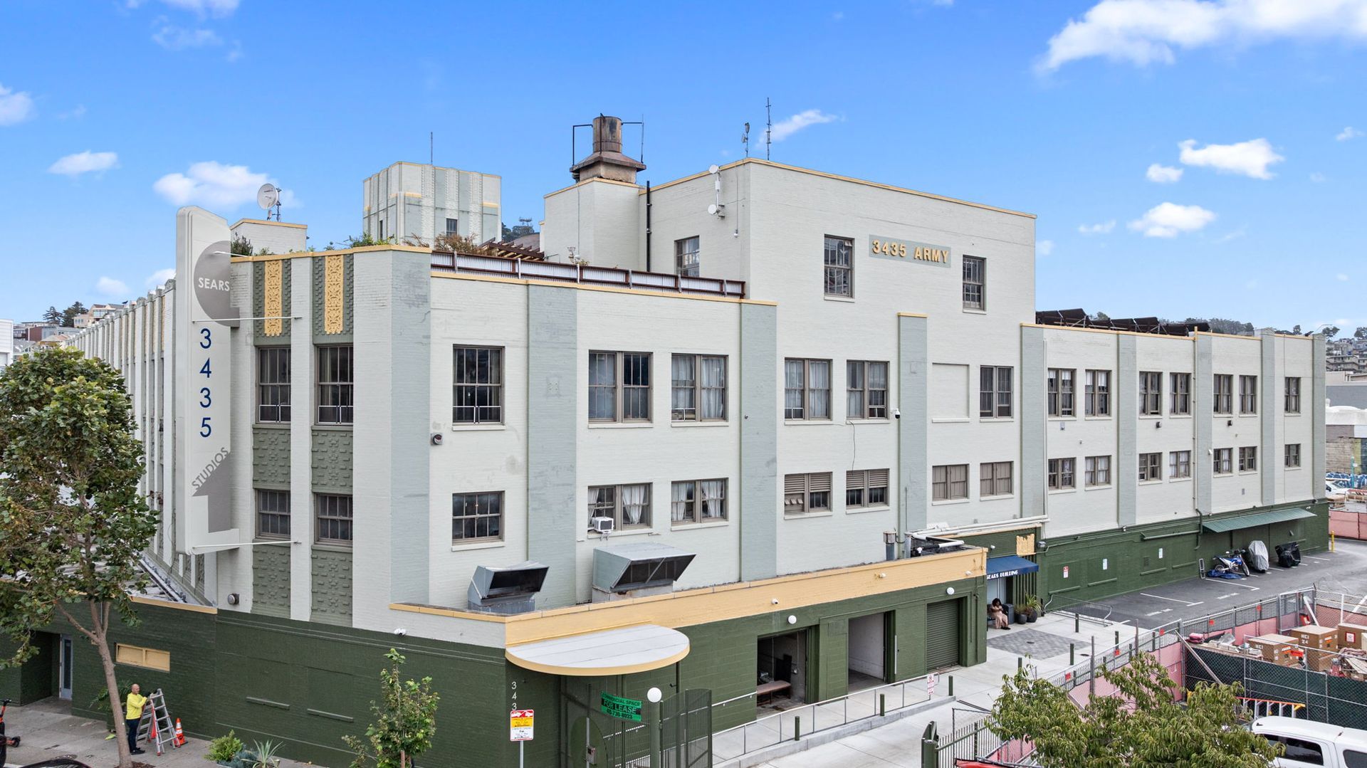 Three-story building with green and white facade;