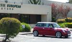 Red Mini Cooper parked in front of a building labeled