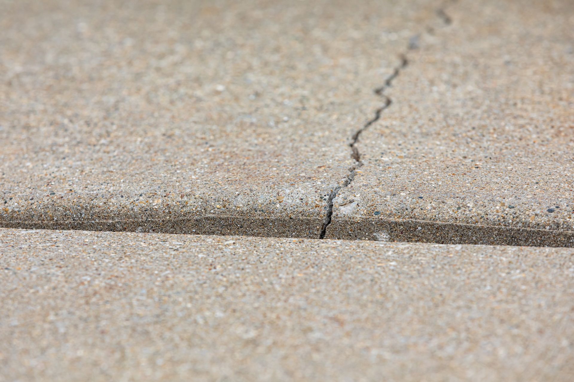 Cracked concrete sidewalk with a visible horizontal seam