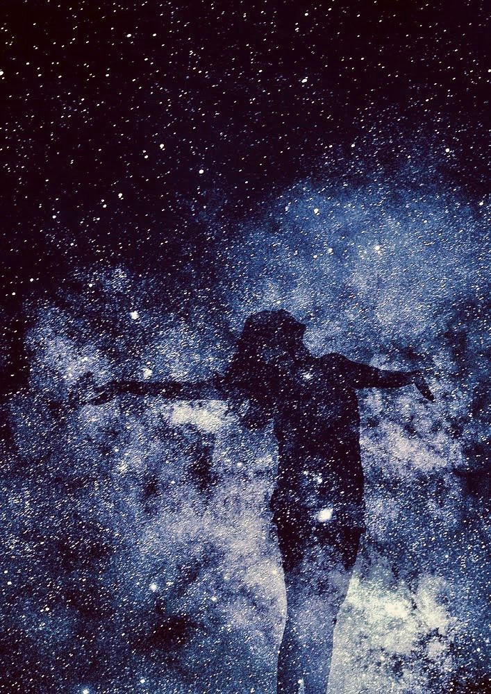 A person is standing in the middle of a galaxy with their arms outstretched