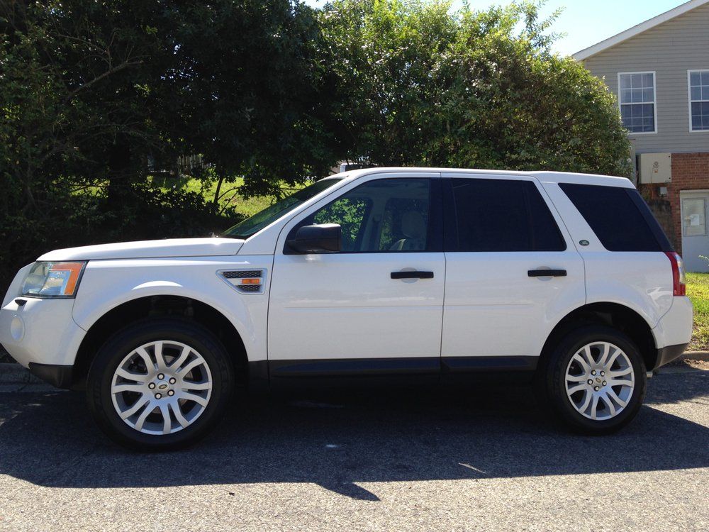 A white suv is parked in front of a house