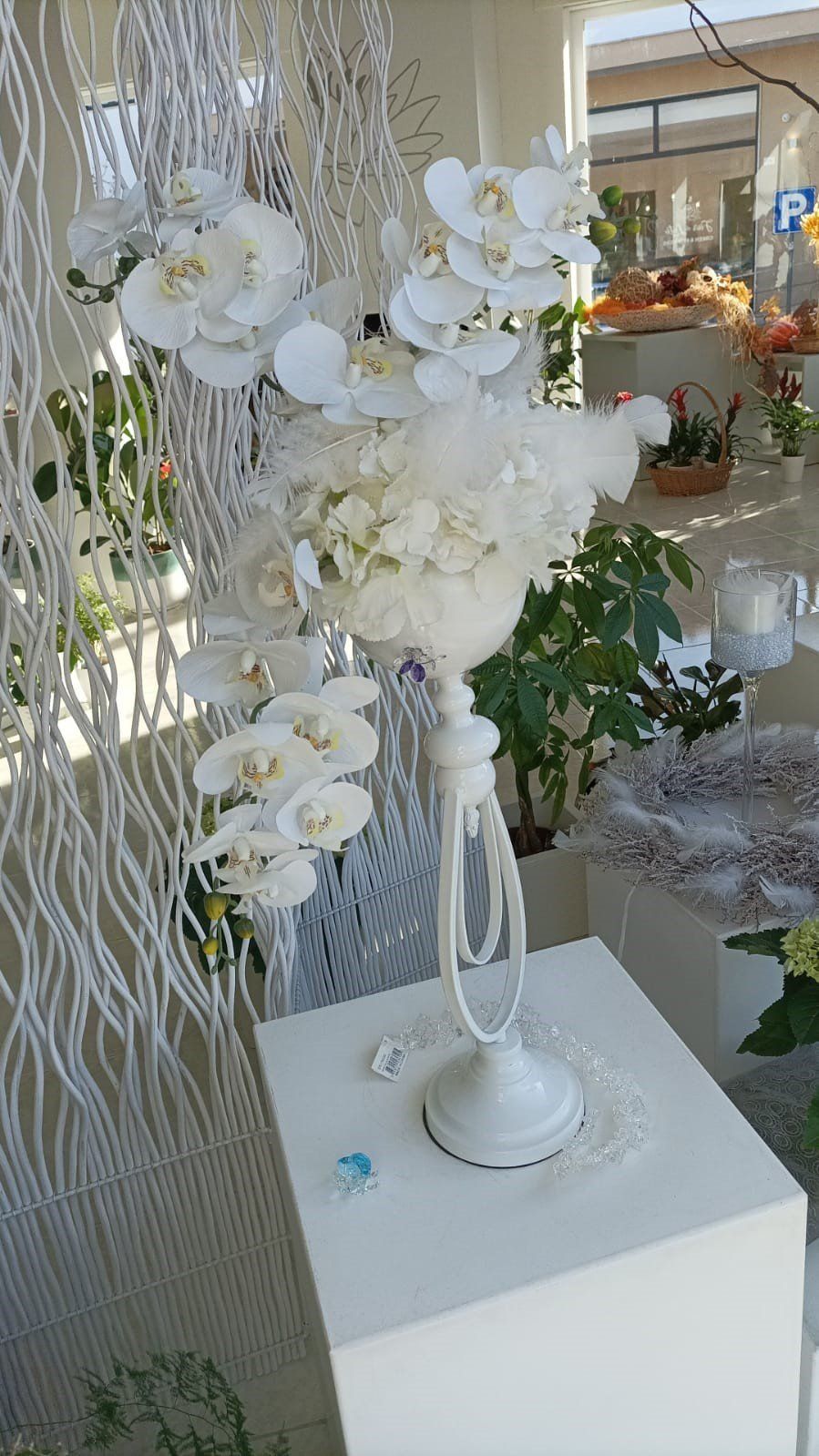 Composizione floreale bianca con orchidee su un piedistallo