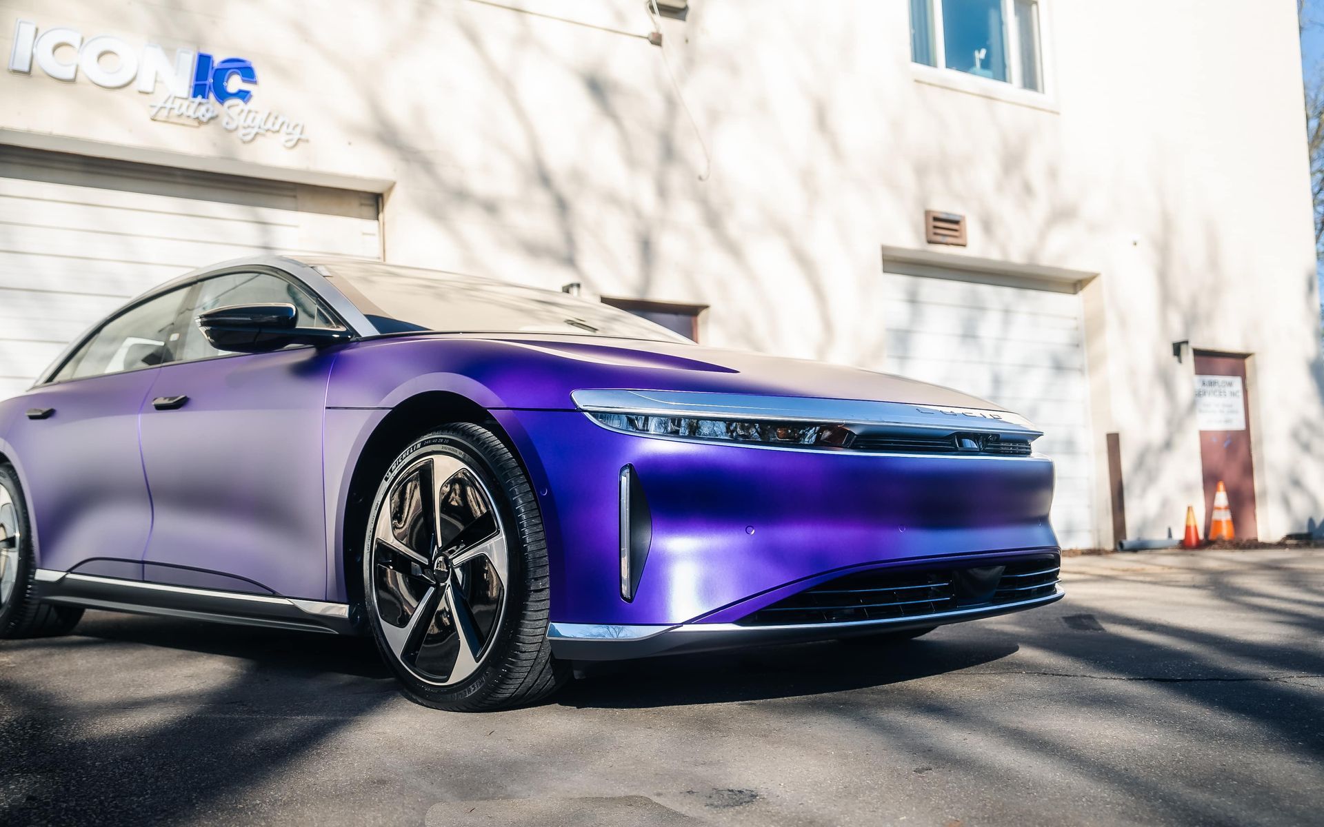 Purple Lucid Air electric car parked outside a building with the