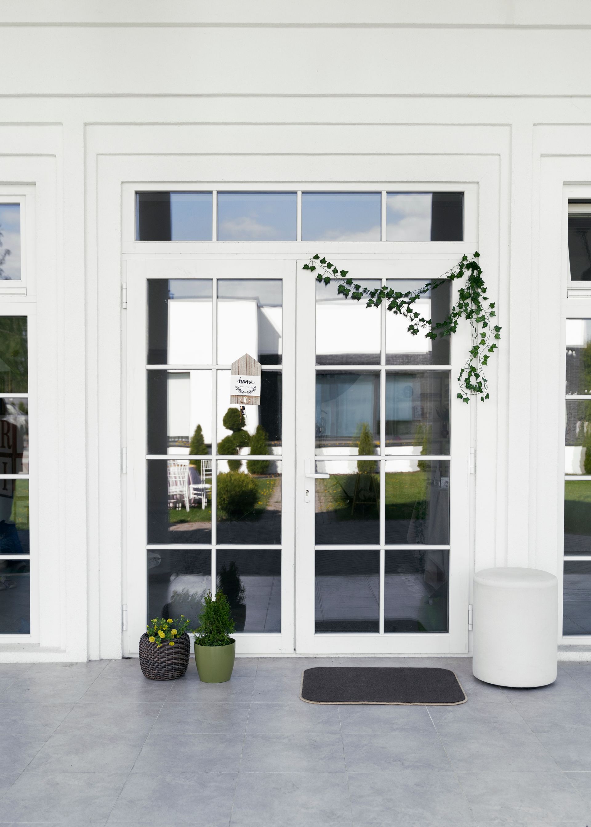 White double doors with glass panels and a greenery garland.