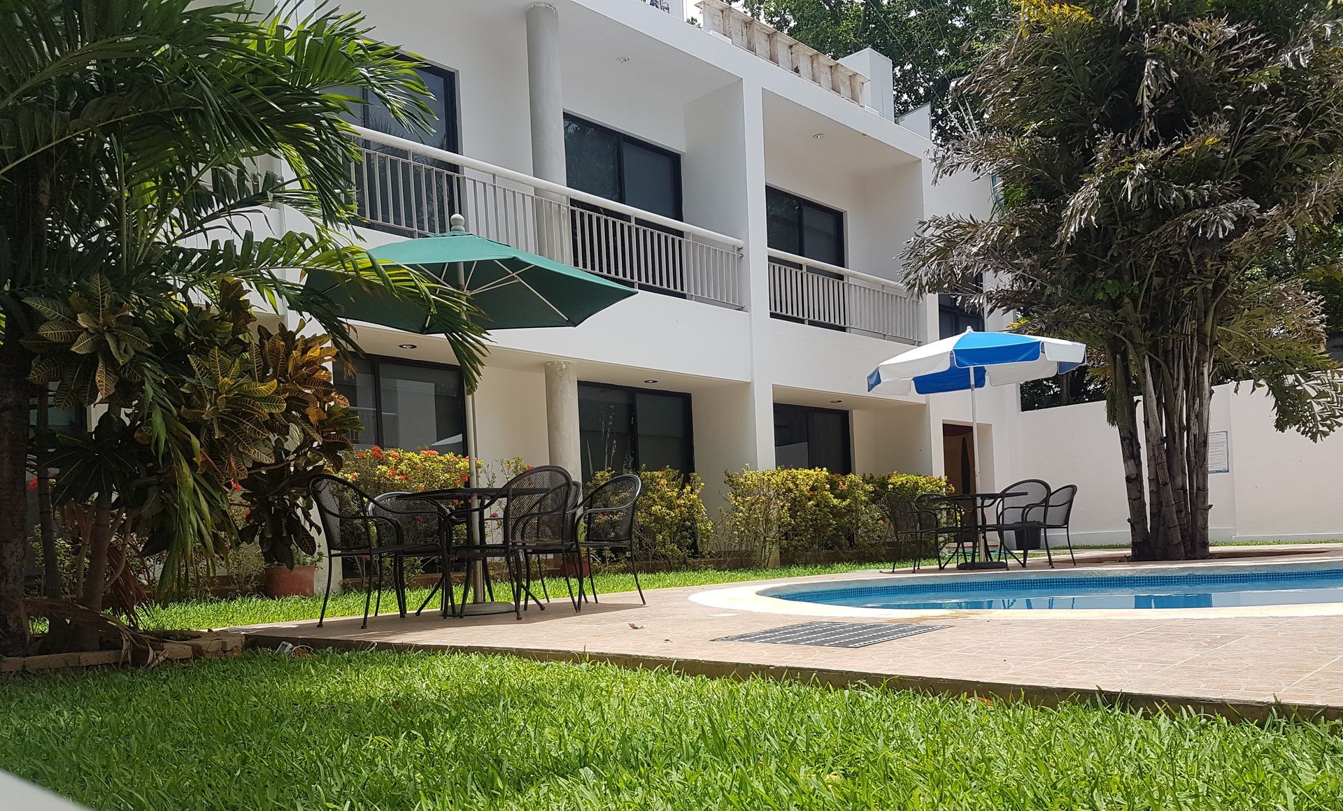 Una gran casa blanca con una piscina en frente de ella.
